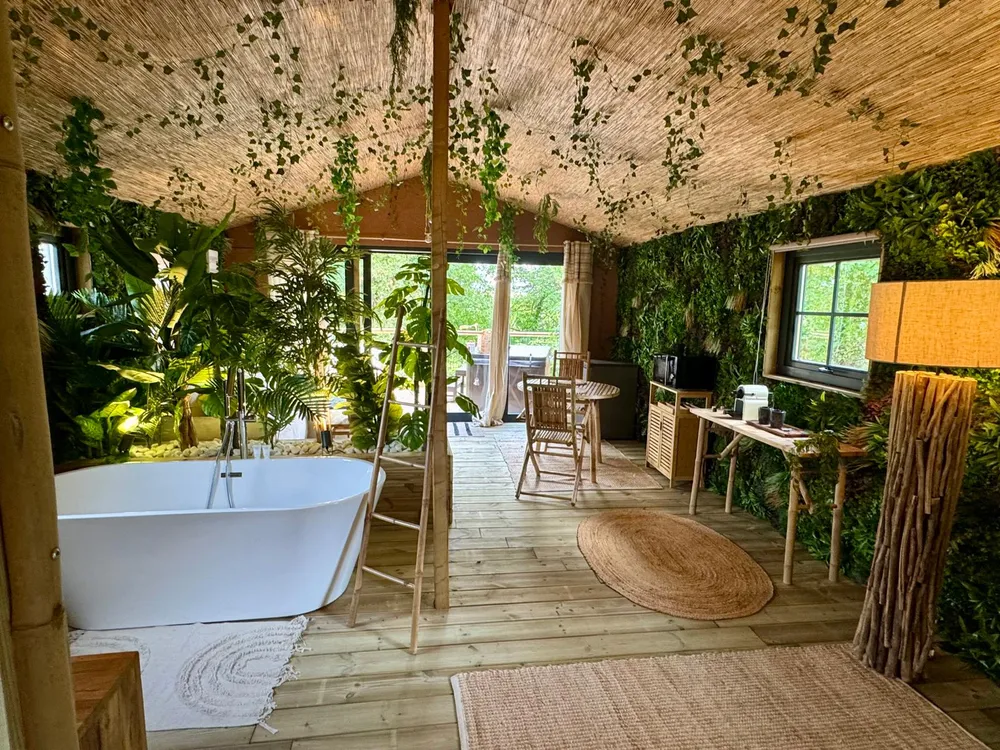 Baignoire autoportante et mur végétalisé dans le Jungle Lodge, hébergement insolite avec décoration jungle