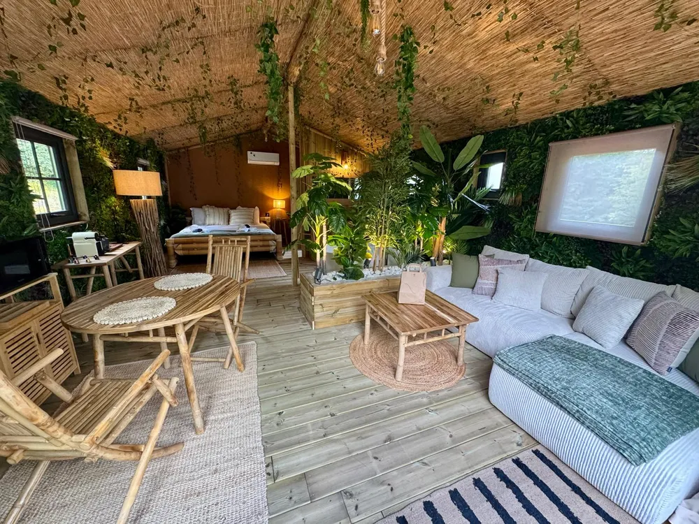 Vue d'ensemble de la pièce de vie du Jungle Lodge, un chalet immersif décoré sur le thème de la jungle